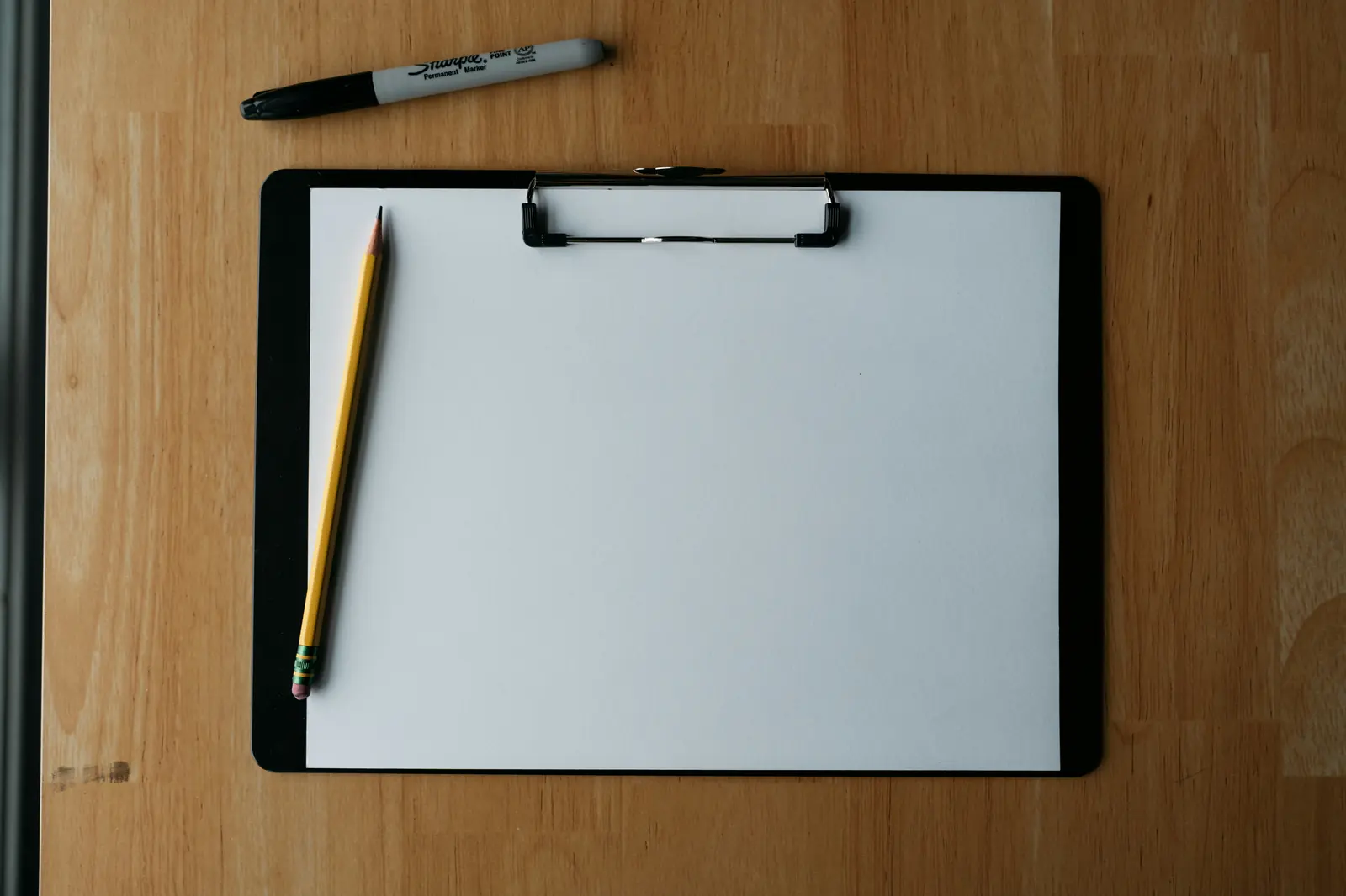 A clipboard and pen, representing the insurance and coverage-area checklist we run on a tree professional before routing any request to them
